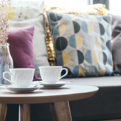 White coffee cup with flower vase on table decoration with pillow on sofa interior - Vintage Filter